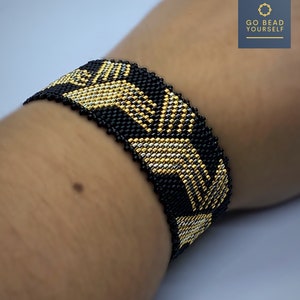 May include: A black and gold beaded bracelet with a geometric pattern. The bracelet is made with small beads and has a woven design.