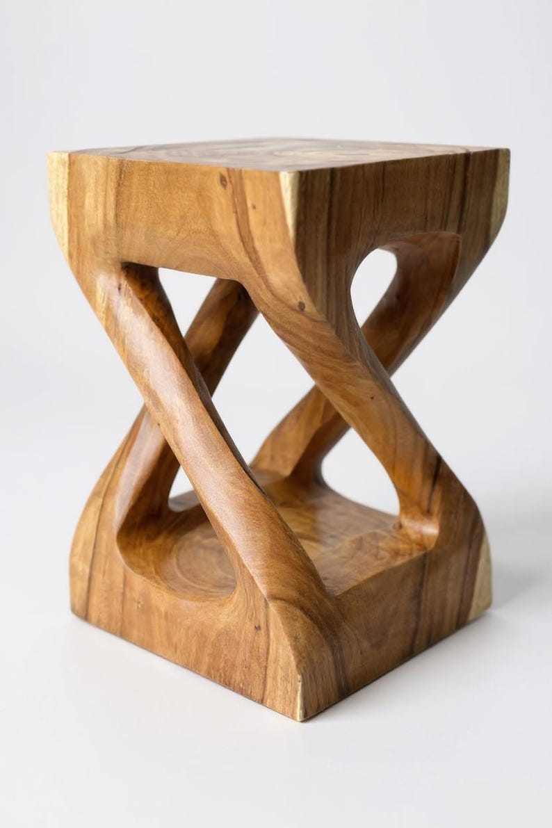 May include: A handcrafted wooden stool with a unique hourglass-like design. The stool is made of light brown wood and features a square top and base, with curved, intersecting supports. The open design adds a modern touch to this functional piece.