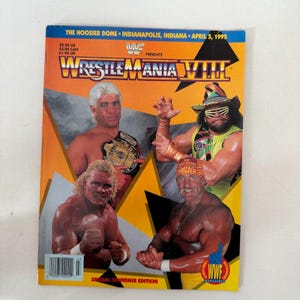 May include: A vintage WrestleMania VIII souvenir magazine cover featuring four professional wrestlers. The cover is predominantly orange and yellow, with the event title in large, bold letters. The text includes "The Hoosier Dome, Indianapolis, Indiana, April 5, 1992."