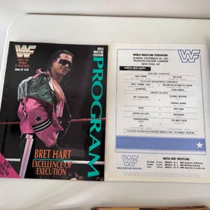 May include: A vintage WWF wrestling program featuring Bret Hart on the cover. The program is open, displaying event details from Madison Square Garden, New York, on December 29, 1991. The cover has the text "Bret Hart Excellence of Execution".
