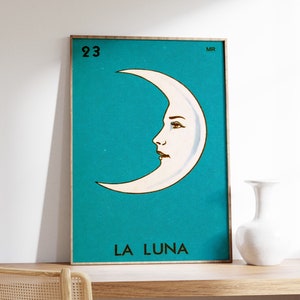 K&ouml;nnte beinhalten: Ein t&uuml;rkisblaues Poster mit einem wei&szlig;en Halbmond mit einem Gesicht. Das Poster tr&auml;gt die Nummer 23 und den Text "LA LUNA".