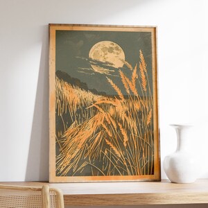 Peut inclure: Une impression encadrée d'un champ de hautes herbes éclairé par la lune avec une pleine lune en arrière-plan. L'herbe est de couleur orange clair et la lune est jaune pâle.