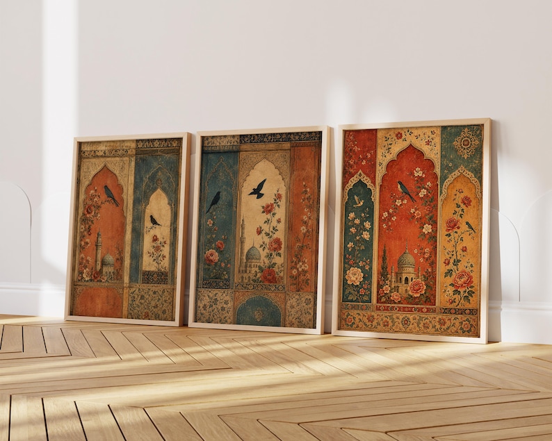 May include: Three framed art prints featuring a vintage design with arched windows, birds, and floral patterns. The color palette includes shades of orange, blue, and gold. The prints are displayed on a wooden floor against a white wall.