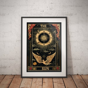 Op de afbeelding: Een zwarte en gouden tarotkaart met de tekst "THE SUN" en een illustratie van een gevleugelde cherub die vliegt voor een zon met een gezicht en stralen van licht.
