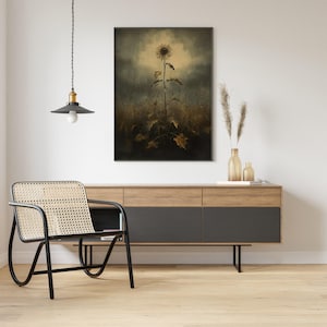 Peut inclure: Une impression encadr&eacute;e en noir d'un seul tournesol dans un champ avec une esth&eacute;tique vintage d&eacute;lav&eacute;e. Le tournesol est grand et mince avec un centre jaune et des p&eacute;tales bruns. L'arri&egrave;re-plan est d'un brun et d'un gris ternes avec un effet atmosph&eacute;rique brumeux.