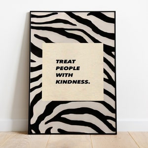 May include: A framed print with a black and white zebra print background. The print features the text "Treat People With Kindness."