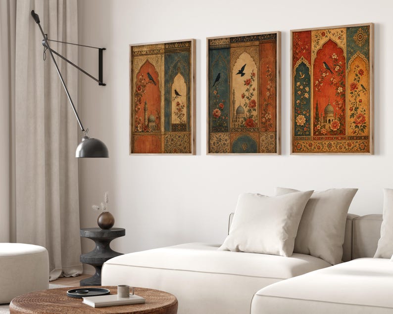 May include: Three framed wall art pieces with an ornate, vintage design. Each features a central archway with floral and architectural elements, a bird, and a color palette of red, blue, and gold. The frames are a light brown color.
