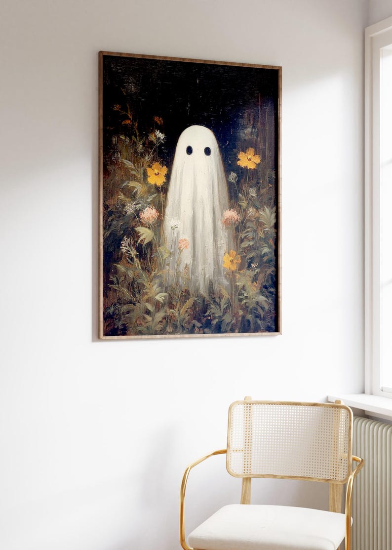 K&ouml;nnte beinhalten: Gerahmter Kunstdruck mit einem wei&szlig;en Geist mit zwei schwarzen Augen, der inmitten eines Feldes aus gelben und rosa Blumen steht. Das Kunstwerk hat eine Vintage-&Auml;sthetik mit dunklem Hintergrund und Holzrahmen. Thema: Halloween.