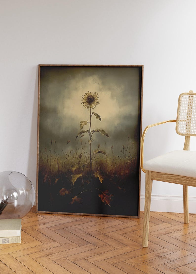 Peut inclure: Une impression encadr&eacute;e d'un seul tournesol se dressant dans un champ d'herbes et de feuilles s&eacute;ch&eacute;es. Le tournesol est jaune avec un centre fonc&eacute; et est &eacute;clair&eacute; par une lumi&egrave;re vive. L'arri&egrave;re-plan est d'un vert et d'un brun ternes.