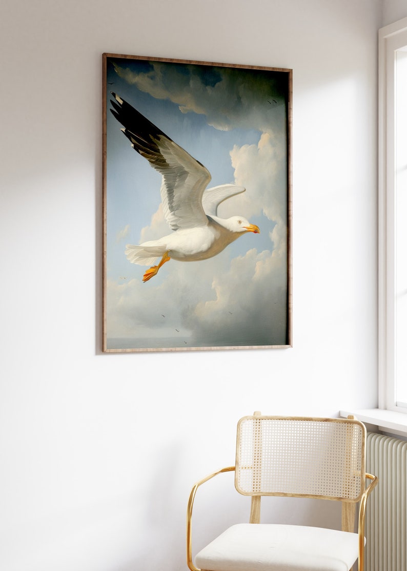 Puede incluir: Una pintura enmarcada de una gaviota blanca con puntas de alas negras volando en un cielo nublado. La gaviota est&aacute; enfocada y el cielo est&aacute; desenfocado en el fondo.