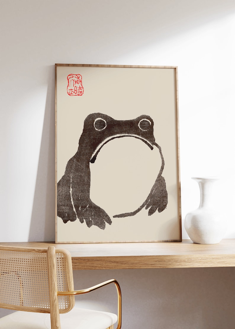 May include: A framed black and white illustration of a frog with a red stamp in the top left corner. The stamp contains Japanese characters.