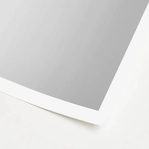 May include: A close-up of a white sheet of paper with a gray border. The paper is slightly curled at the bottom.