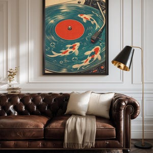 Puede incluir: Una impresi&oacute;n art&iacute;stica enmarcada que presenta un dise&ntilde;o de tocadiscos vintage con peces koi nadando en el disco. La obra de arte tiene una combinaci&oacute;n de colores turquesa y naranja, con un marco negro. La impresi&oacute;n se muestra sobre un sof&aacute; de cuero marr&oacute;n.
