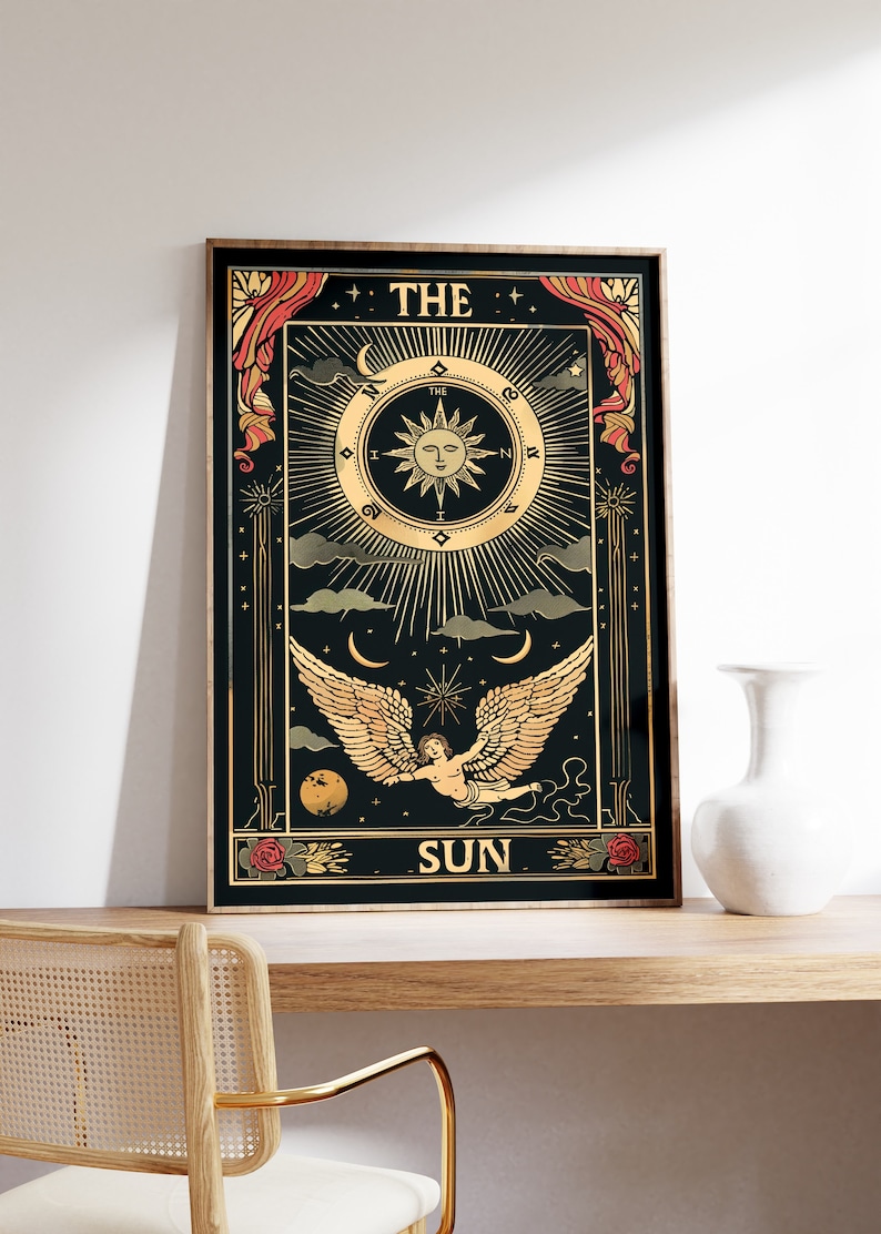 Op de afbeelding: Een zwarte en gouden tarotkaart met de afbeelding van een ge Fl&uuml;gelde engel die in de lucht vliegt. De kaart is getiteld "De Zon" en heeft een zon met een gezicht in het midden.