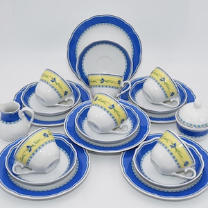 Könnte beinhalten: Ein blaues und gelbes Blumen-Tee-Set mit Milchkännchen und Zuckerdose. Das Set enthält sechs Teetassen und Untertassen.