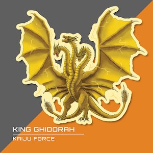 Può includere: Un adesivo raffigurante King Ghidorah, un drago dorato a tre teste con grandi ali e motivi a fulmine. Il testo "KING GHIDORAH" e "KAIJU FORCE" sono stampati sotto. L'adesivo ha un bordo bianco su uno sfondo grigio e arancione.