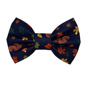 May include: A navy blue bow tie with a pattern of squirrels, leaves, and mushrooms.