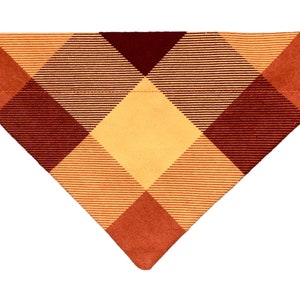 May include: A triangular dog bandana with a plaid pattern in shades of orange, yellow, and brown.