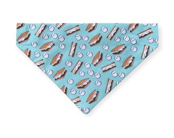 May include: A turquoise blue dog bandana with a pattern of brown and tan s'mores. The s'mores are made of graham crackers, chocolate, and marshmallows.