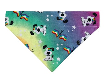 May include: A rainbow ombre dog bandana with a white background and a repeating pattern of white dogs wearing rainbow flags on their heads and white stars.