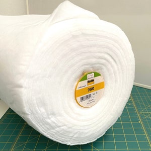 Peut inclure: Un rouleau blanc d'entoilage 100% PES, 280 grammes par mètre carré, 90 cm de large et 1,5 mètre de long. L'étiquette est jaune avec du texte noir et un logo vert.