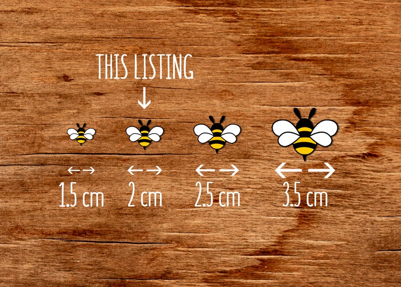 May include: Four bee illustrations in different sizes on a wood background. The bees are yellow and black with white wings. The sizes are 1.5 cm, 2 cm, 2.5 cm, and 3.5 cm.