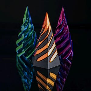 May include: Three decorative pyramid-shaped ornaments with a metallic finish. The ornaments are green, orange and purple. The ornaments are reflected on a black surface.