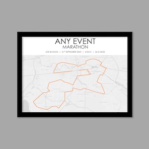 May include: Framed print featuring a marathon route map in Berlin, Germany. The route is highlighted in orange against a grayscale map background. The text "ANY EVENT MARATHON" is at the top, with runner details below. The frame is black.
