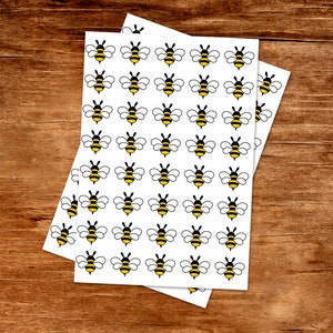 May include: A sheet of white paper with a repeating pattern of black and yellow bee illustrations.