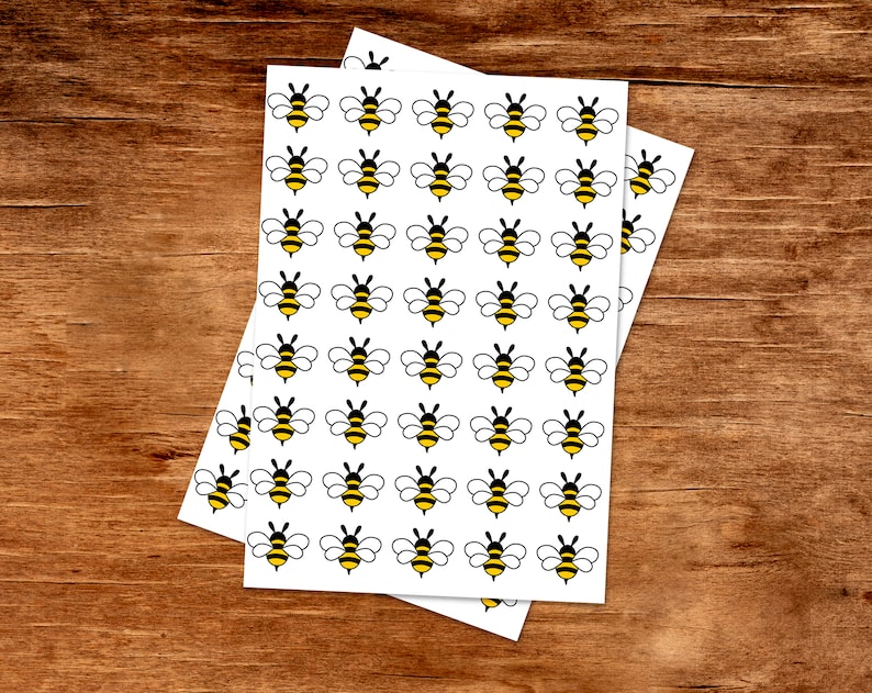 May include: A sheet of white paper with a repeating pattern of black and yellow bee illustrations.