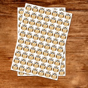 Puede incluir: Dos hojas de papel blanco con pegatinas de b&uacute;ho marrones. Cada hoja tiene 49 pegatinas de b&uacute;ho.