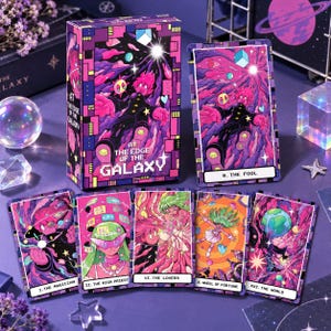 Peut inclure: Un jeu de cartes de tarot intitulé At The Edge Of The Galaxy avec des illustrations cosmiques aux tons vifs de violet, rose et bleu. Le coffret comprend une boîte rectangulaire et plusieurs cartes illustrées de personnages de style anime.