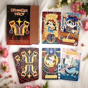 May include: A deck of Dramagiac Tarot cards featuring a box with a jester hat graphic and the text Where Paws Decode Destiny and Tails Wag The Future. Four cards are displayed showing illustrations of dogs as The Fool, The Magician, The High Priestess, and The Empress.