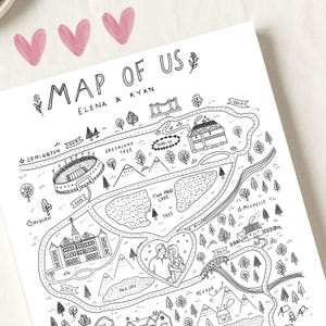 May include: A white paper print featuring a black ink line drawing titled MAP OF US with the names ELENA & RYAN. The illustration depicts a winding road map with various landmarks, trees, mountains, lakes, and a central heart containing a couple.
