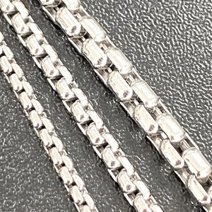 Puede incluir: Tres cadenas de plata de diferentes grosores, cada una con un patrón de cadena de caja.