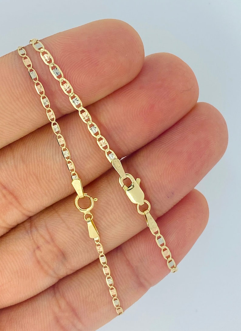 Op de afbeelding: Twee gouden kettingen met een diamantgeslepen ontwerp. De kettingen zijn van verschillende lengtes en zijn gemaakt van geel, wit en ros&eacute;goud.