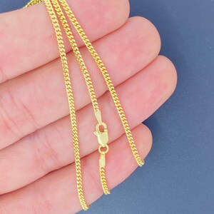 May include: A gold chain necklace with a lobster clasp fastening. The chain is made of a delicate, fine-link design.