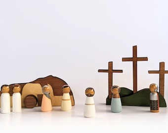 Könnte beinhalten: Holzfiguren-Set, das die Geschichte der Kreuzigung Jesu Christi darstellt. Das Set enthält Figuren von Jesus, seinen Jüngern und drei Holzkreuzen.