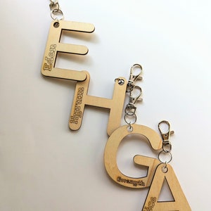 May include: Wooden keychains with the letters E, H, G, and A. Each letter has a name engraved on it: Eden, Hyrum, Gwyneth, and Alice.