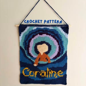 May include: A rectangular crochet wall hanging featuring a stylised figure in an orange top against a swirling blue and purple tunnel background. The text CROCHET PATTERN appears at the top, and the name Coraline is stitched in yellow at the bottom.