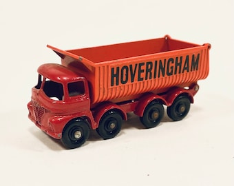 Könnte beinhalten: Ein roter Spielzeug-Kipplaster mit einem schwarzen "HOVERINGHAM"-Schild an der Seite. Der Laster hat vier Räder und eine hochgeklappte Ladefläche.