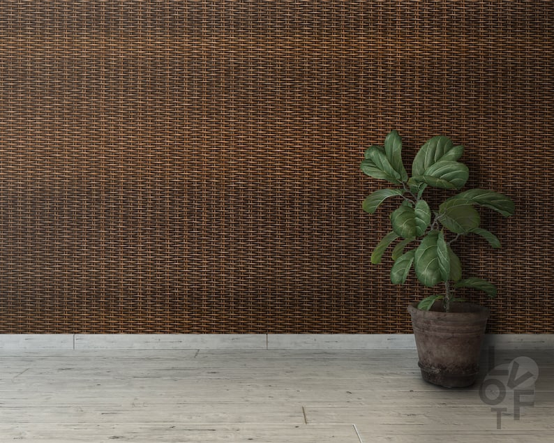 Puede incluir: Una planta en maceta con hojas verdes se encuentra en un suelo de madera clara frente a una pared tejida de color marr&oacute;n.