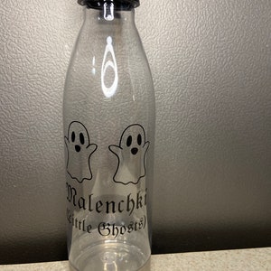 May include: Clear plastic water bottle with a stainless steel lid and base. The bottle has two black ghost silhouettes and the text "Malenchk (Little Ghosts)" printed on the side.