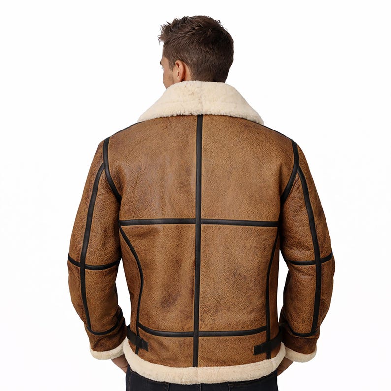 May include: Brown leather jacket with a cream-colored shearling collar and lining. The jacket features black trim and a classic design. A warm and stylish outerwear piece.