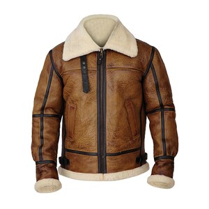 May include: Brown leather jacket with a cream-colored shearling collar and lining. The jacket features a zip-up front, black trim, and a classic aviator style. The cuffs and hem are lined with cream-colored shearling.