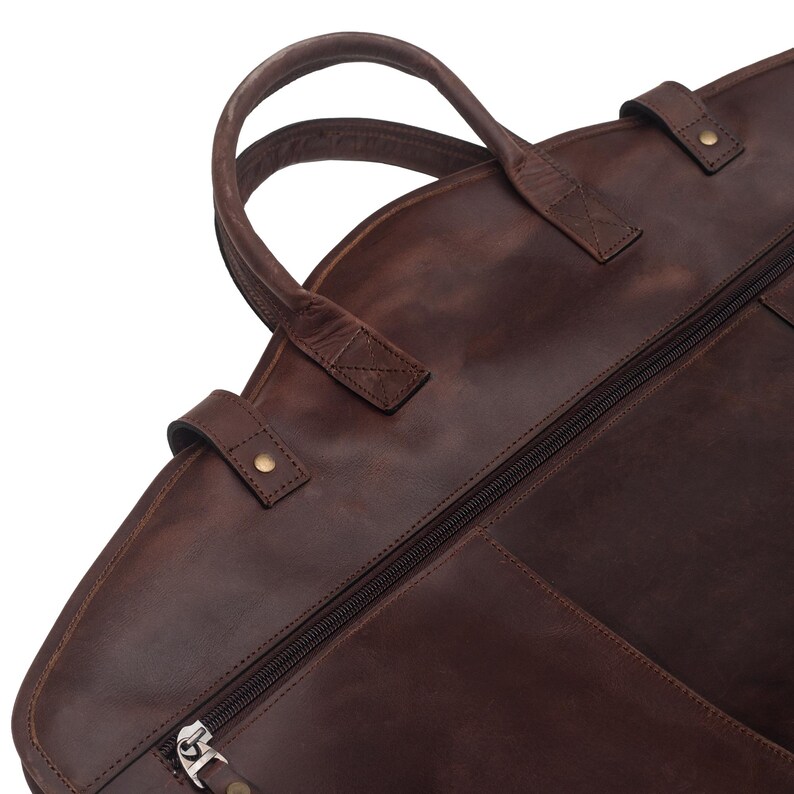 May include: A brown leather garment bag with a zipper closure and a top handle.