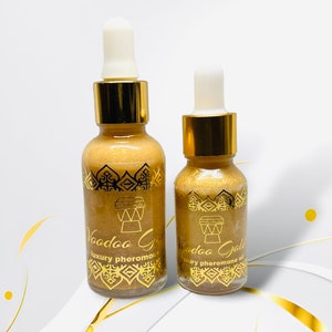 May include: Two gold bottles with droppers, both labeled "Voodoo Gold" and featuring a gold drum design. The larger bottle says "luxury pheromone oil" and the smaller bottle says "luxury pheromone oil".
