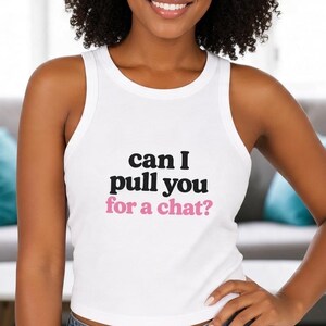 May include: A white sleeveless tank top featuring the black text can I and pull you with the pink text for a chat? printed on the front. The garment has a ribbed texture and a high neckline, providing a clean and simple aesthetic.