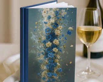 May include: A hardcover journal with a blue spine and a floral design. The cover features a vertical arrangement of blue and cream-colored flowers against a light blue background. The journal is open, revealing white pages.