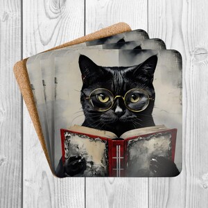 May include: Set of four square coasters featuring a black cat wearing round gold-rimmed glasses and reading a book with a red cover. The cat is depicted in a vintage, painterly style, with a neutral background. The coasters have a cork backing.